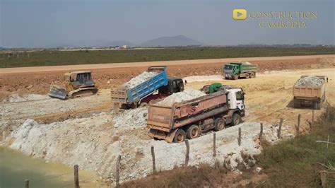 New Project Bulldozer Pushing Dirt And Dump Trucks Unloading Dirt To