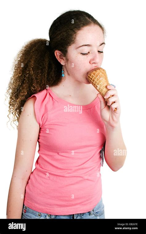 Cute Hispanic Latina Teenage Girl With Curly Hair And Freckles Eating A Chocolate Ice Cream