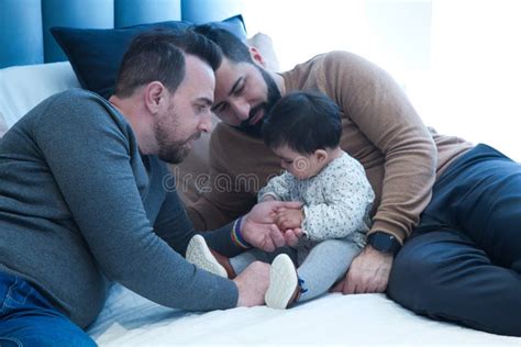 Pareja Gay Jugando Con Su Hija En La Cama De Matrimonio En Su Casa Foto De Archivo Imagen De