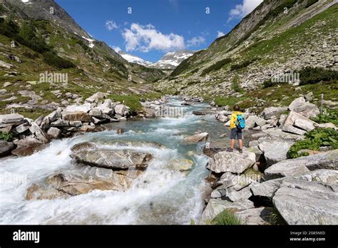 Boy Standing Near Glacier Stream In Hohe Tauern National Park While