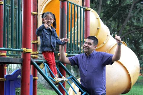 Dad With His Brunette Latina Daughter Play In The Park In The Games