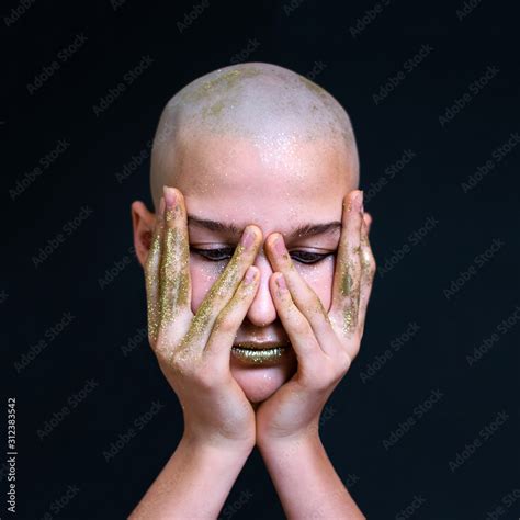 Photo Naked Bald Girl In Gold Sparkles Hands On Face Portrait Dark Background Stock Photo