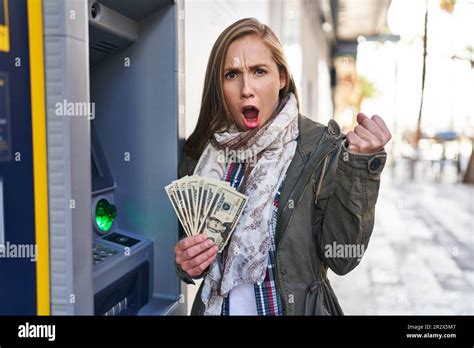 Une Jeune Femme Blonde Qui Tenait Des Billets De Banque En Dollars Dans Un Distributeur