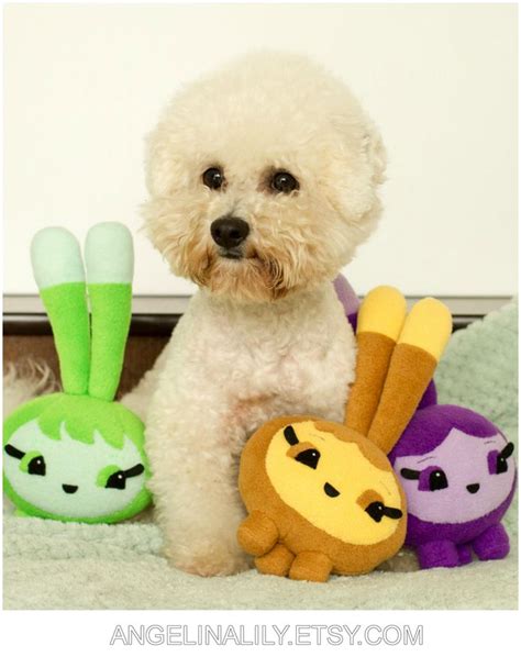 a small white dog sitting next to stuffed animals