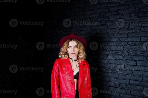 Studio Portrait Of Blonde Girl In Red Hat And Leather Jacket Against Brick Wall 10417469 Stock