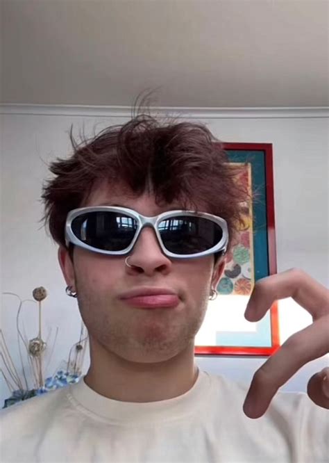 A Man Wearing Sunglasses Making A Funny Face With His Fingers In Front