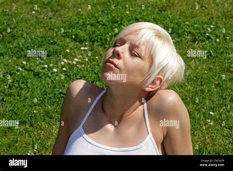 Jeune femme blonde se faire bronzer sur la pelouse Banque de photographies et dimages à haute