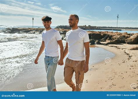 Joven Pareja Gay Sonriendo Feliz Caminando En La Playa Foto De Archivo Imagen De Pares Fondo