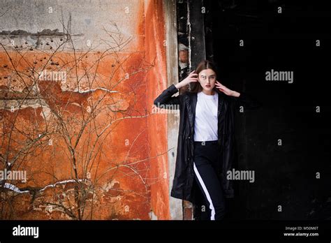 Fashionable Long Legs Brunette Model In Long Black Cloak Posed Outdoor At Winter Day Against Old