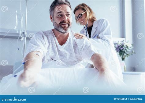 Mature Man Sitting In Hospital Bed And Physician Doing Checkup Stock Photo Image Of Hospital