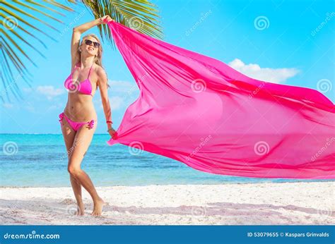 Mujer En El Bikini Rosado Que Sostiene La Tela Rosada En Viento En La