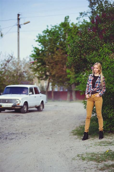 Femme Assez Blonde Sur Une Route Rustique Sur Un Fond D Un Bon Nombre Des Arbres Verts Et De