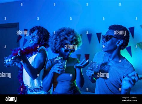 Drunk Friends Partying And Dancing At Home At Night With Colorful Neon