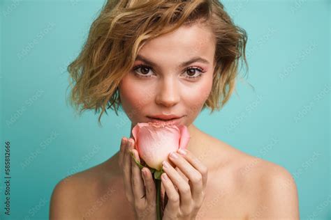 Beauty Portrait Of Naked Woman Posing With Rose Isolated Over Blue Background Stock Photo