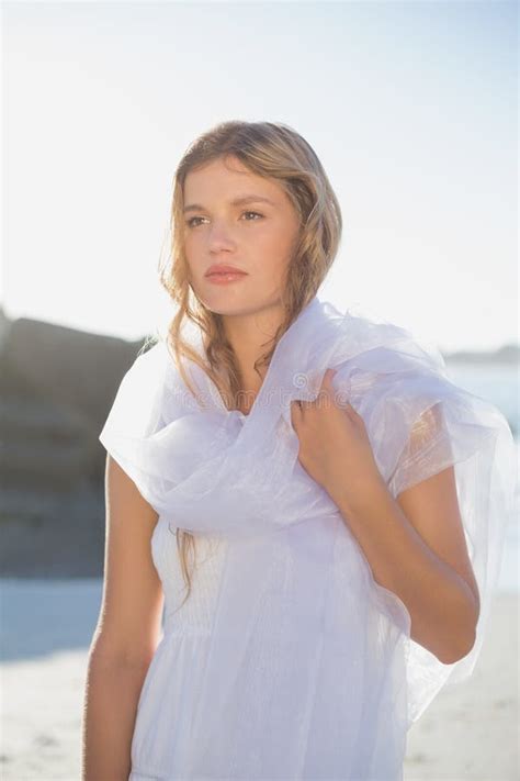 Beautiful Blonde In White Sundress And Scarf On The Beach Stock Photo