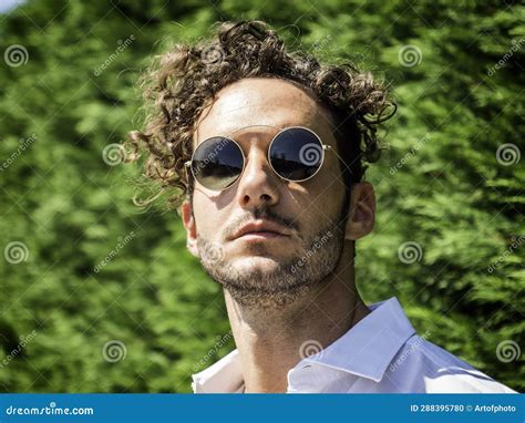 Photo Of A Stylish Man With Curly Hair And Sunglasses Stock Photo