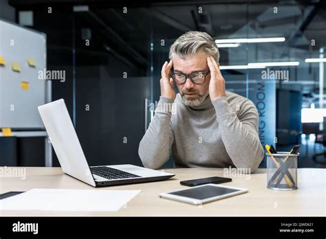 Sick Mature Businessman Working In Modern Office Senior Experienced Man Having Severe Headache