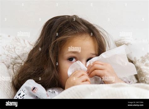 Adorable petite fille de brunette crachée nez soufflant avec des mouchoirs regardez l appareil