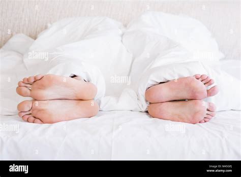Bare Feet Of Gay Couple Out From The Blanket Stock Photo Alamy