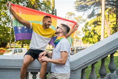 Pareja Gay Abrazando Y Mostrando Su Amor Con La Bandera Del Arco Iris Foto Premium
