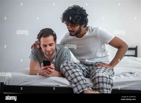 Concentrated Gay Couple Viewing Selfies On The Cellphone Stock Photo Alamy