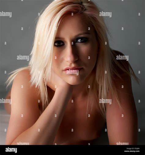 A Nude Blonde Girl Lies In The Studio She Looks Seductively To Camera Stock Photo Alamy