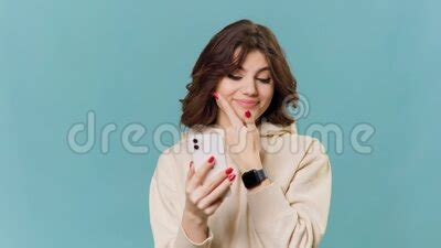 Brunette Adolescente S Amuse Avec Son Smartphone Dans Sa Main Pointant Son Doigt Sur Son Visage