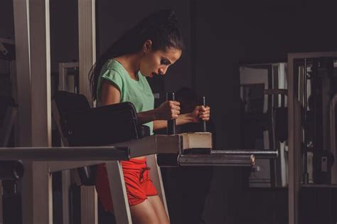 Jeune Belle Athlète Blonde Sexy Bodybuilder Exerce Dans La Salle De Gym Dans De Beaux Vêtements