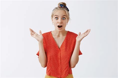 Surpris Jeune Fille Blonde Posant Contre Le Mur Blanc Photo Gratuite