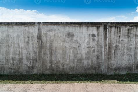 Old Cracked Gray Cement Or Concrete Wall With Blue Sky As Background