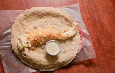 Quesillo tradicional nicaragüense servido en mesa de madera primer