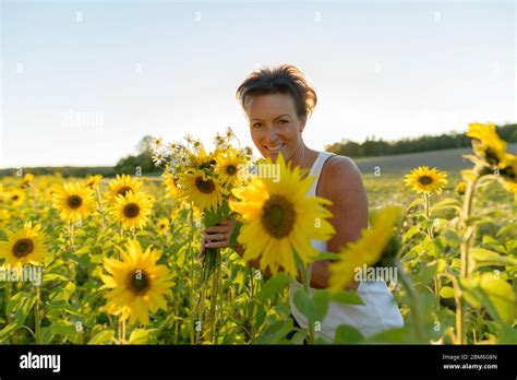 Bonne Mature Belle Femme Tenant Des Fleurs Dans La Ferme De Jardin De Tournesol Photo Stock Alamy