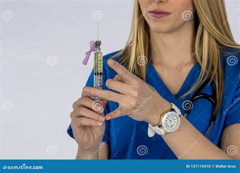 Hot Blonde Nurse Performing Her Duites Against A White Background In A Studio Environment Stock