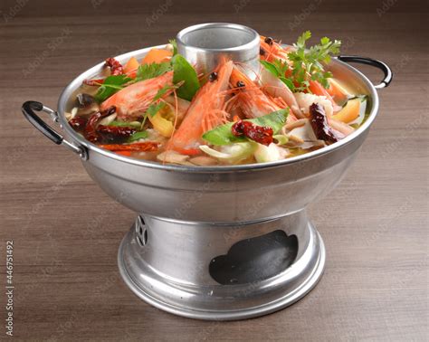 Thai Clear Tom Yum Spicy Chilli Hot Soup With Seafood Meat And Vegetables In Hot Pot In Wood