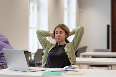 Premium Photo Tired Female Mature Student Taking Break Stretching Arms While Studying Online