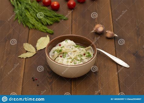 Bolas De Masa Hervida Rusas De La Carne Del Pelmeni Con Verdes En La