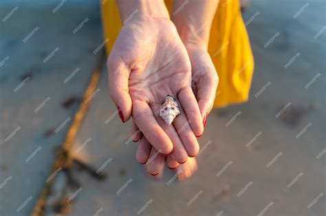 Premium Photo Top View Of A Girl In A Yellow Dress Holding A Seashell