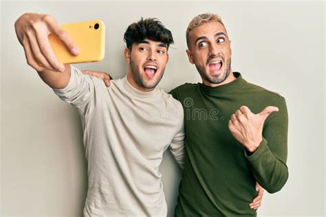 Homosexual Gay Pareja De Pie Juntos Tomando Una Foto Selfie Con Smartphone Apuntando Pulgar