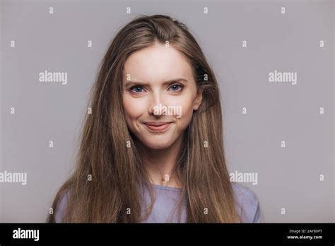 Brunette Delighted Blue Eyed Female Model With Satisfied Expression