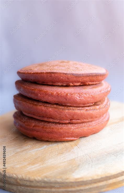 Pila De Hot Cakes Esponjosos Sabor Fresa Integral Sobre Base De Madera Circular Y Fondo Claro