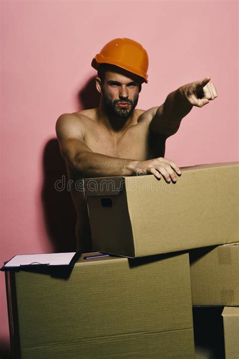 Sexuality And Moving Concept Guy With Torso Stands Naked Behind Boxes