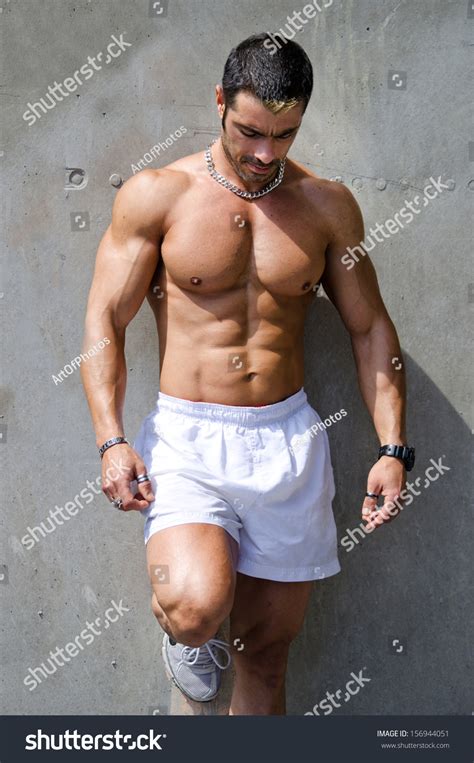 Muscular Male Bodybuilder Standing Against Wall Outdoors Shirtless