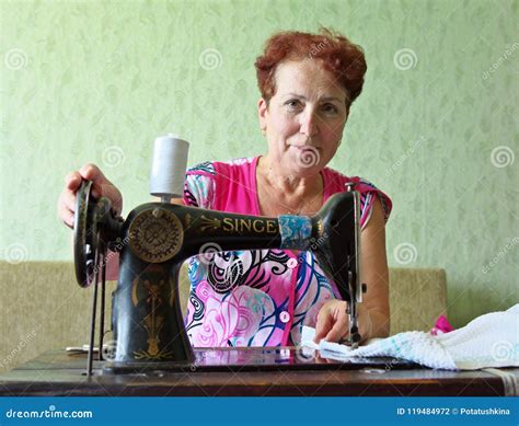 An Elderly Woman Sews On An Old Sewing Machine Editorial Photography