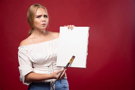Artiste Blonde Montrant Son œuvre Et Semble Douteuse Photo Gratuite