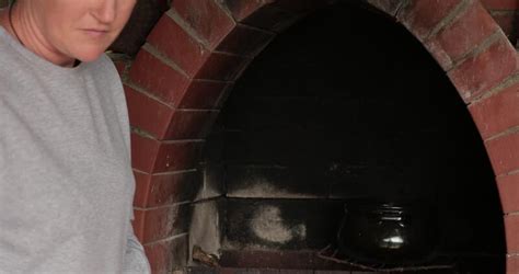 S Brunette Woman Cook Food In Cooking Clay Pot On Open Fire Into Brick Furnace Stir Food