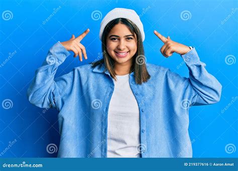Joven Latina Con Gorra Linda De Lana Sonriendo Apuntando A La Cabeza
