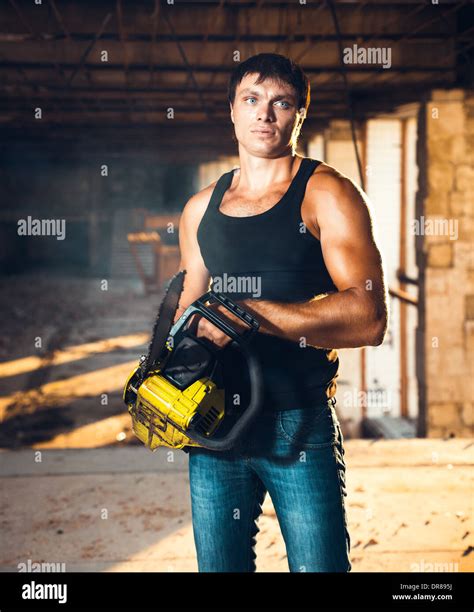 Muscular Man With A Chainsaw On The Ruins Stock Photo Alamy