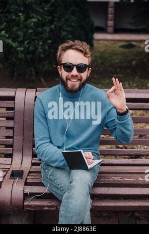 Jeune Gay Hipster Gar On Avis Des Id Es Siting Dans Un Parc Et Couter De La Musique Par Des