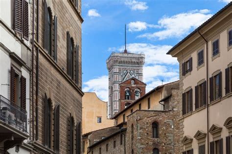 Premium Photo | Campanile and bell tower over urban houses