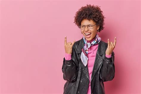Free Photo | Positive fashionable curly woman makes rock n roll gesture ...